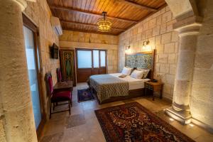 a bedroom with a bed in a stone walled room at Cappadocia Sweet Cave in Nevşehir +72 photos