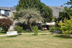 een parkbankje in de tuin van een huis bij Logis Hermitage in Perros-Guirec