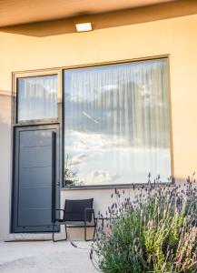 a glass door with a chair in front of a window at The Lynx Konitsa in Konitsa