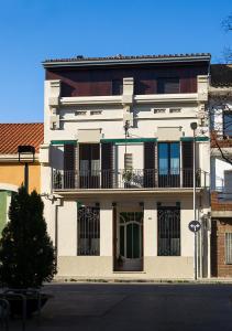 a white building with a balcony on a street at Cal Peó B&B Cardedeu in Cardedeu