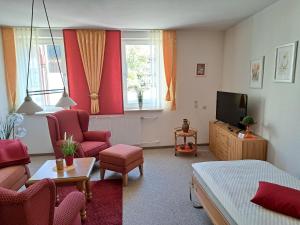 a living room with a bed and a tv at Haus Lieberum in Bad Sooden-Allendorf