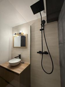 a bathroom with a shower with a sink and a mirror at Studio Montagne chic centre station in Le Lioran +41 photos