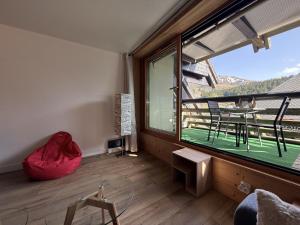 a room with a large window and a table and chairs at Studio Montagne chic centre station in Le Lioran