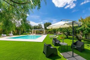 a garden with a swimming pool and an umbrella at Blue Coast Luxury Private Villa, Pool, Jacuzzi, Guesthouse in Bisceglie