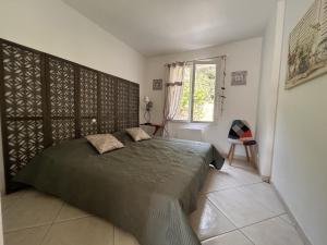 a bedroom with a bed and a window at Villa du Bonheur Carambole in Saint-Georges-dʼOléron