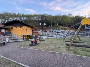 a playground with a slide and a swing set at Casa Iris in Omegna