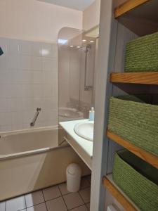 a bathroom with a sink and a tub and a toilet at Studio avec balcon, 4 personnes in Quiberon