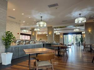 a restaurant with tables and chairs and a bar at Livingston Hotel in Sandakan