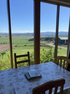 a table with a laptop on it in front of a window at The Bothy in Lumphanan