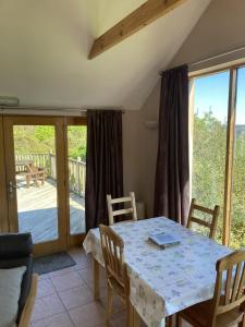 a dining room with a table and chairs and a patio at The Bothy in Lumphanan