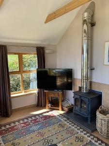 a living room with a tv and a stove at The Bothy in Lumphanan