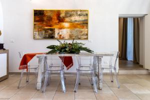 a dining room table with chairs and a painting on the wall at Blue Coast Luxury Private Villa, Pool, Jacuzzi, Guesthouse in Bisceglie +83 photos