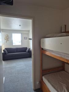 a room with a bunk bed and a couch at Studio avec balcon, 4 personnes in Quiberon