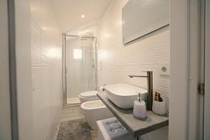 a white bathroom with a sink and a toilet at La casa di Penelope in Catania +16 photos
