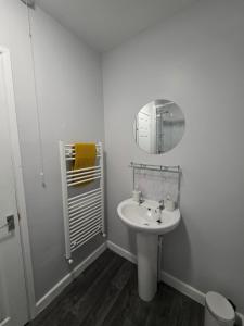 a white bathroom with a sink and a mirror at Central Guest House in Newport +24 photos