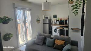 a living room with a couch and a kitchen at Zen et cosy in Marseille +10 photos
