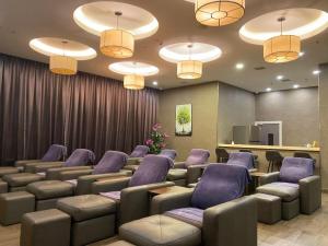 a waiting room with couches and chairs and lights at Livingston Hotel in Sandakan