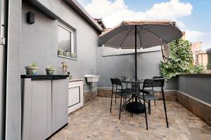a patio with a table and chairs and an umbrella at La casa di Penelope in Catania