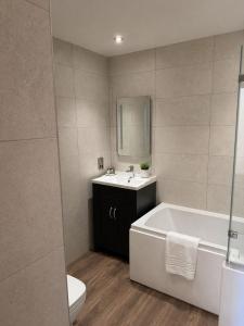 a bathroom with a tub and a sink and a toilet at The Hurt Arms in Whatstandwell