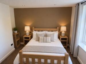 a bedroom with a large bed with two lamps at The Hurt Arms in Whatstandwell