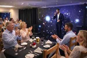 a group of people sitting around a table with a man on a microphone at Royal Seabank Hotel in Blackpool