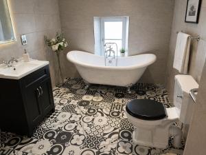 a bathroom with a tub and a toilet and a sink at The Hurt Arms in Whatstandwell