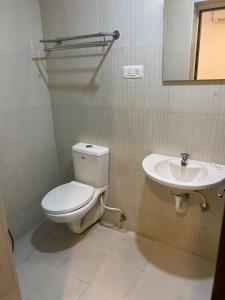 a bathroom with a toilet and a sink at Hotel Blu Ivy in Chennai