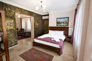 a bedroom with a large bed with a purple blanket at Yellow Stone House in Göreme