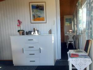 a large white cabinet in a room with a table at Gæstehus Stillinge Strand in Stillinge Strand
