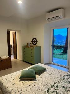 ein Schlafzimmer mit einem Bett, einer Kommode und einem Fenster in der Unterkunft Villa Razeto in Zoagli
