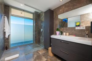 a bathroom with a sink and a shower with a window at Villa Roca Llisa in Santa Eularia des Riu +13 photos