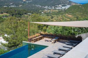 a house with a swimming pool with a table and chairs at Villa Roca Llisa in Santa Eularia des Riu