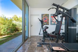 a gym with a treadmill and a elliptical machine at Villa Roca Llisa in Santa Eularia des Riu