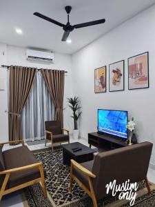 a living room with a couch and a tv at Homestay Seri Damai in Juasseh