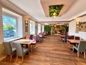 a dining room with wooden tables and chairs at kERVANHOF an der Donau in Kleinpöchlarn