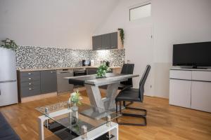 a kitchen with a table and chairs in a room at Paky Appartements 00323 in Bruck an der Leitha