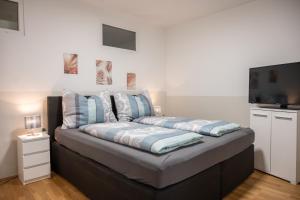 a bed in a room with a flat screen tv at Paky Appartements 00323 in Bruck an der Leitha