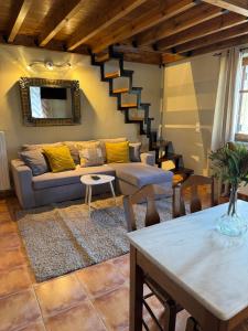 a living room with a couch and a staircase at Frigias 4 in Arachova +1 photo