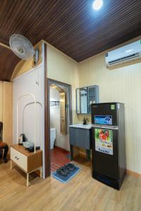 a room with a kitchen with a refrigerator and a sink at Home Đăng Hải in Phú Hiệp