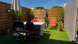 a patio with a table and chairs on the grass at Studio La Parenthèse Sablaise - 3 étoiles in Les Sables-d'Olonne