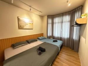 a bedroom with a large bed and a window at Mujito5 15Pax 3BR NearTC, DinosaurLand, PS4 Netflix in Kuantan