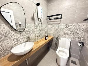 a bathroom with a sink and a toilet and a mirror at Mujito5 15Pax 3BR NearTC, DinosaurLand, PS4 Netflix in Kuantan