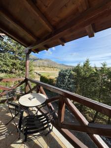 a patio with a table and chairs on a deck at Frigias 4 in Arachova