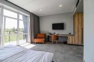 a bedroom with a bed and a desk and a tv at Kryla by Shepilska in Dolgoluka