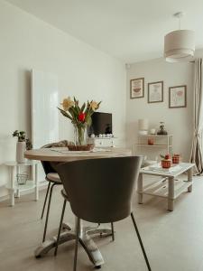 a dining room table with a vase of flowers on it at Studio La Parenthèse Sablaise - 3 étoiles in Les Sables-d'Olonne