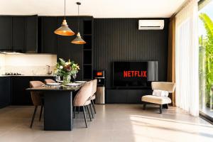 a kitchen with a table and chairs and a television at Premier Umalas Villas in Seminyak