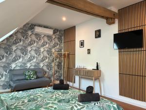 a bedroom with a bed and a tv and a couch at Le domaine du Quercy in Padirac