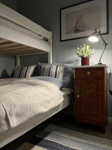 a bedroom with a bunk bed with a lamp and a dresser at Sea house in beautiful surroundings in Haram