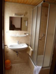 a bathroom with a sink and a shower at Hotel Deutsche Eiche Northeim in Northeim