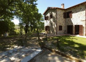 an old stone house with a fence in front of it at Scappo in Umbria, Casale Rusinè in Narni